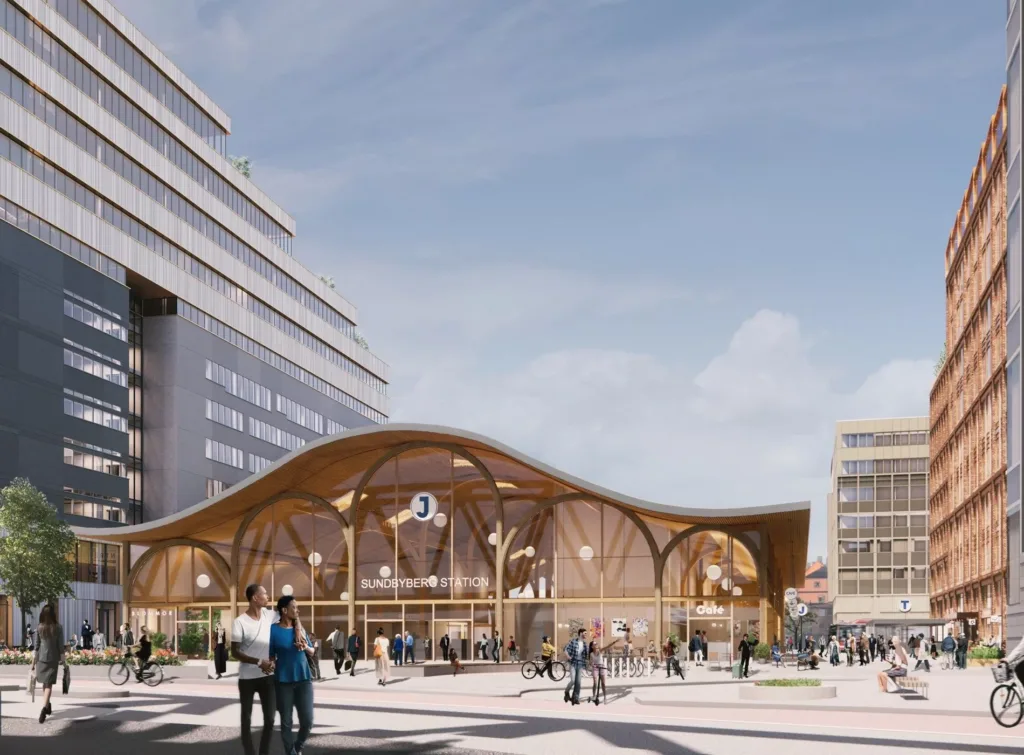 En modern träbyggnad med välvd arkitektur omgiven av höga byggnader och människor.