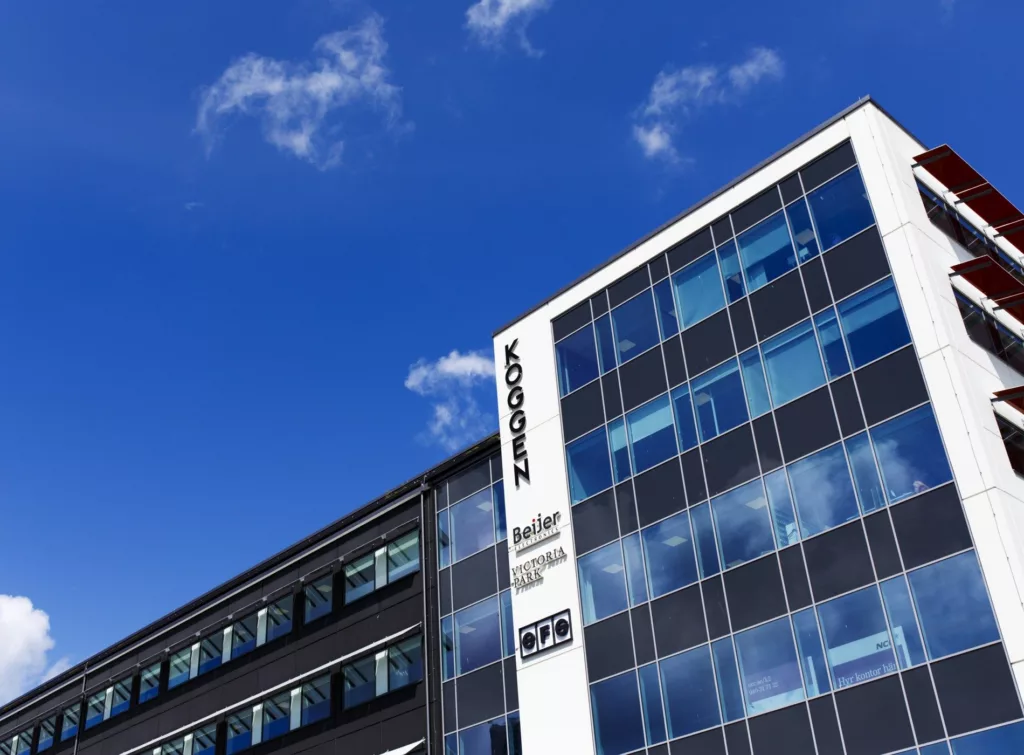 Ett modernt kontorshus med glasfasader och texten "Science Park" på sidan, mot en klarblå himmel.