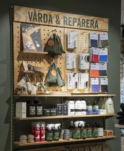 Ett hyllsystem med produkter för vård och reparation, med skylten "VÅRDA & REPARERA" högst upp.