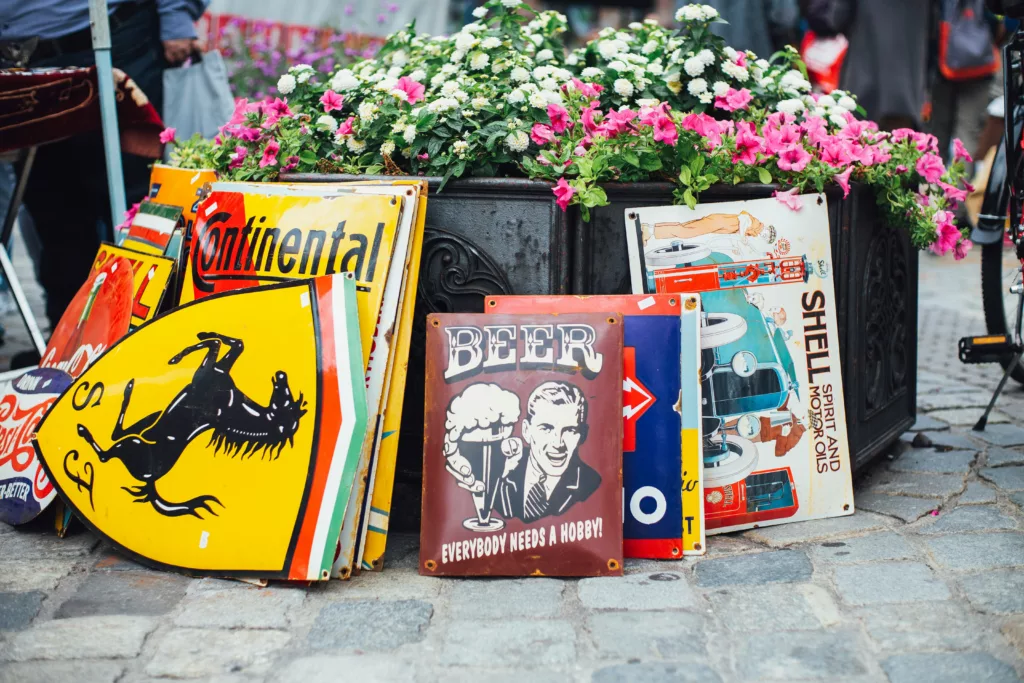 3. Vintage skyltar och affischer, inklusive en med texten "BEER" och bilder av blommor i bakgrunden.