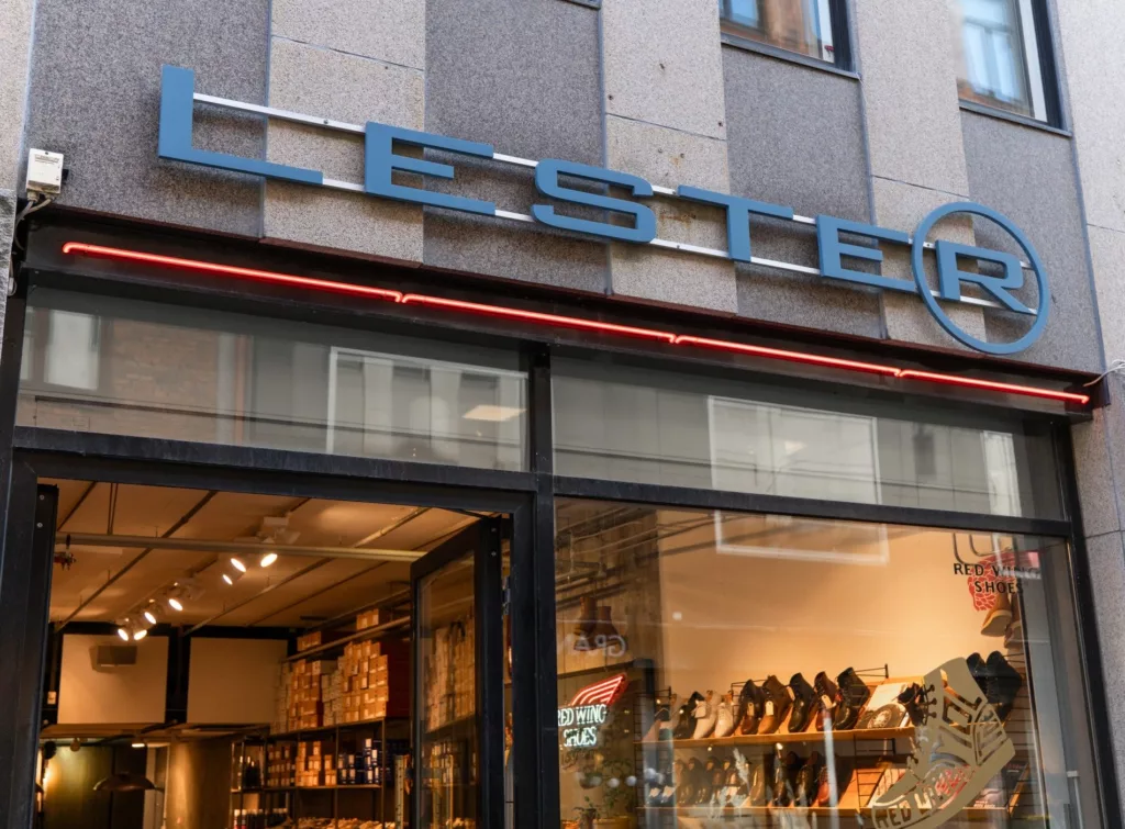 En butik med skylt "Lester" ovanför ingången, med skohyllor synliga från utsidan.