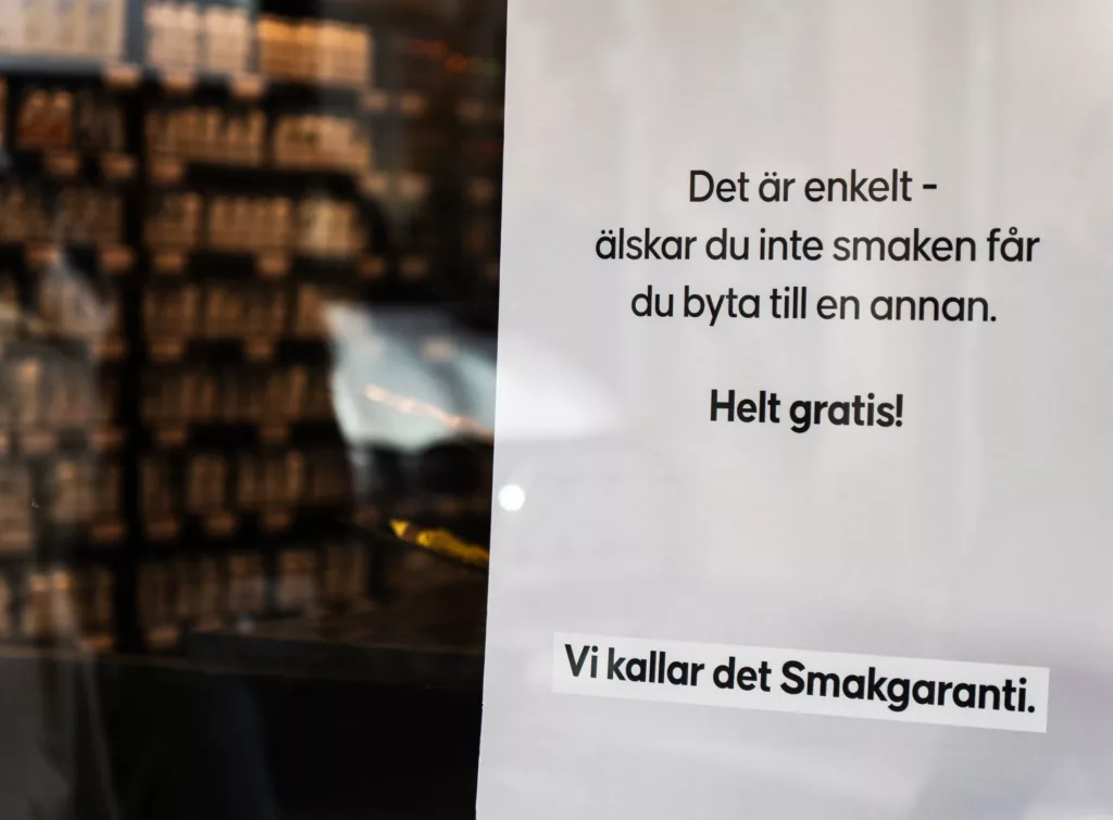 En vit skylt med texten: "Det är enkelt - älskar du inte smaken får du byta till en annan. Helt gratis! Vi kallar det Smakgaranti."