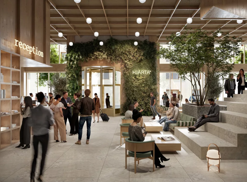 3. En rymlig och modern lobby med människor som samtalar, sittande och stående, samt gröna växter som dekorerar området.