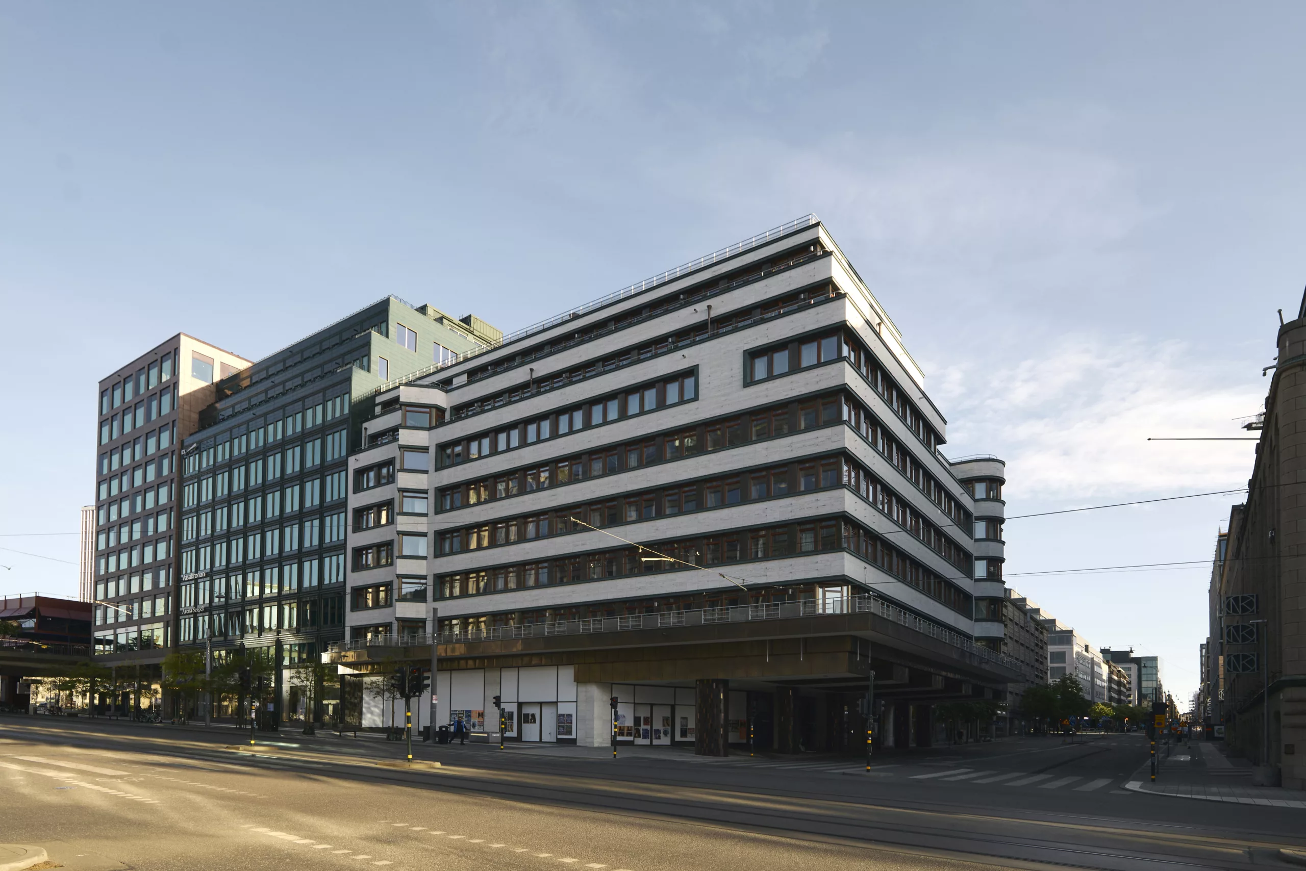 3. Modern byggnad med flera våningar, omgiven av stadsmiljö och blå himmel.