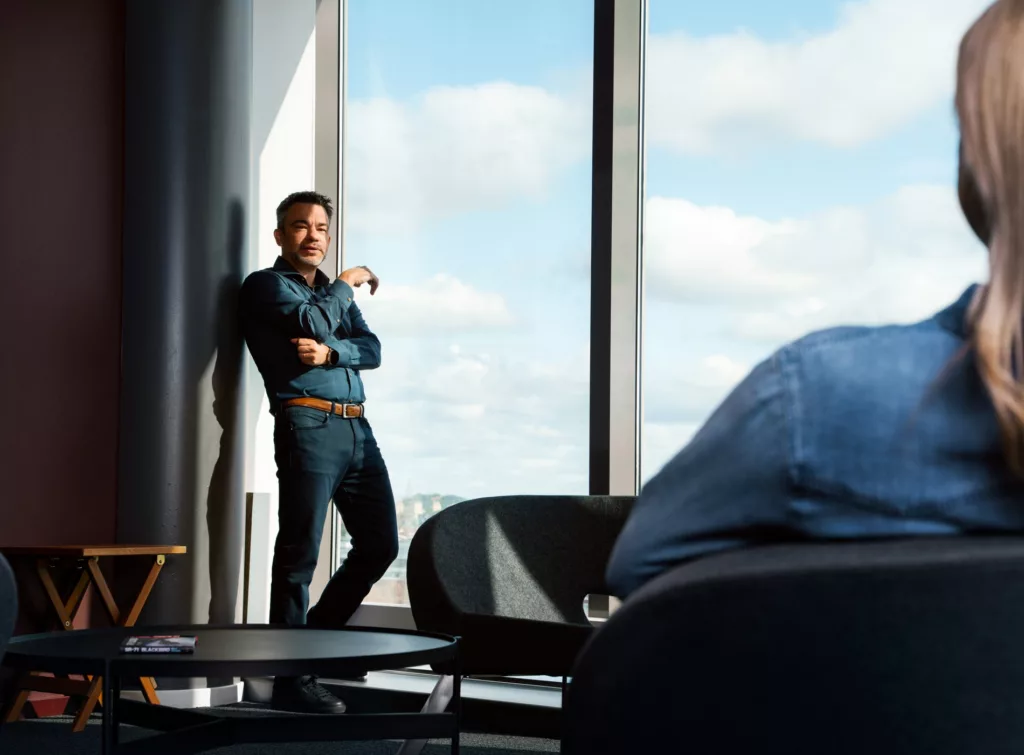 Mikael Grev, vd Avioniq, står lutad mot ett fönster i Kista science tower med utsikt över hela Kista.