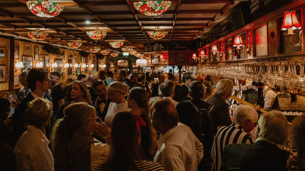 1. En livlig pub fylld med människor, prydd med färgglada lampor och dekorationer.