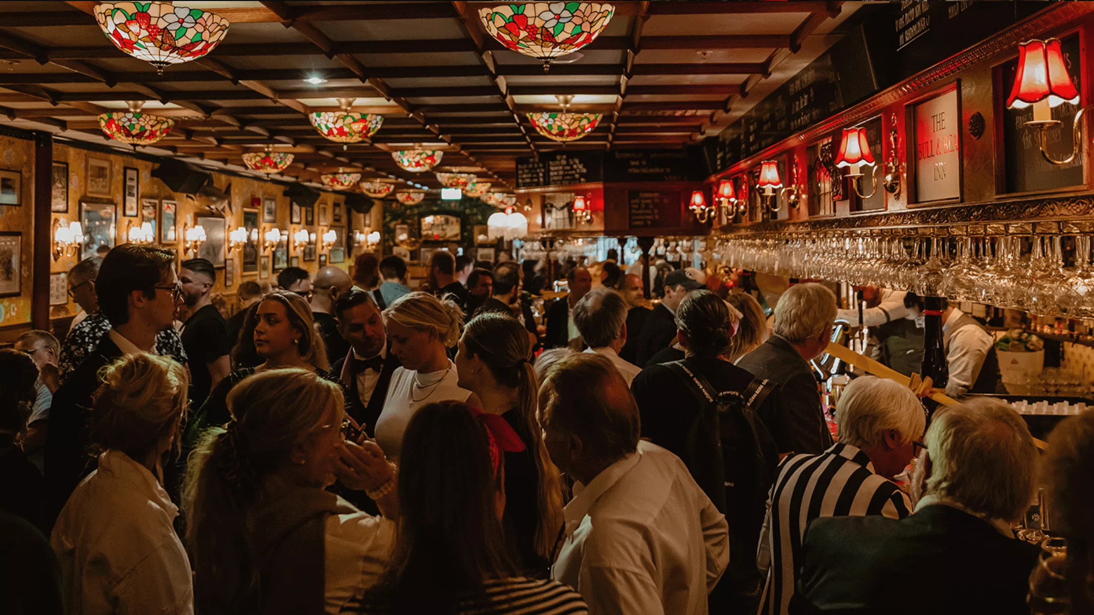 1. En livlig pub fylld med människor, prydd med färgglada lampor och dekorationer.