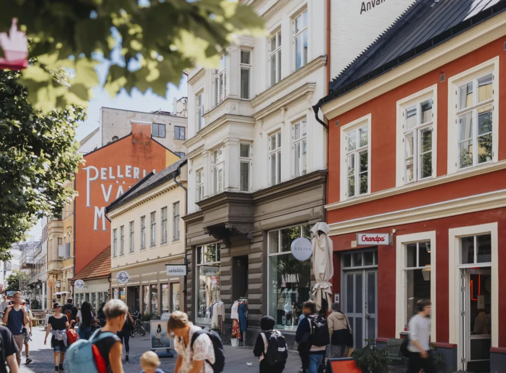 5. En livfull stadsgata med äldre byggnader, affärer och människor som promenerar och interagerar.