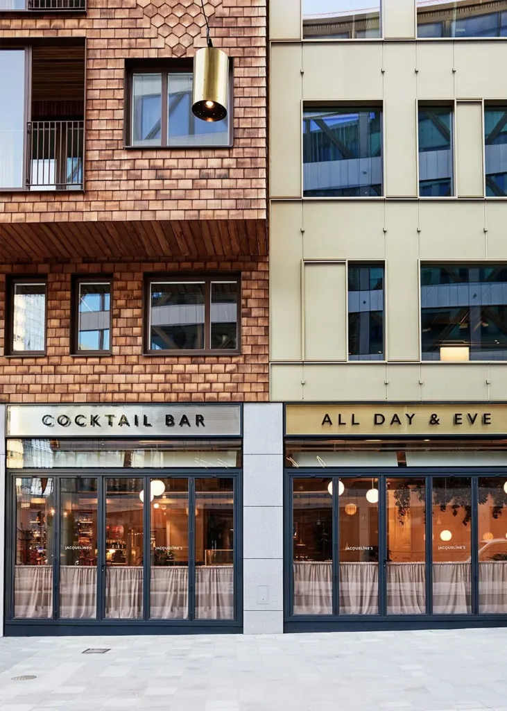 Fasad av två byggnader med texten "Cocktail Bar" och "All Day & Five" ovanför fönstren.