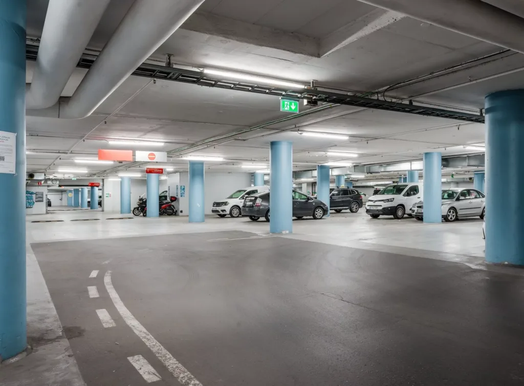 5. En rymlig parkeringsgarage med bilar parkerade vid blåa pelare.