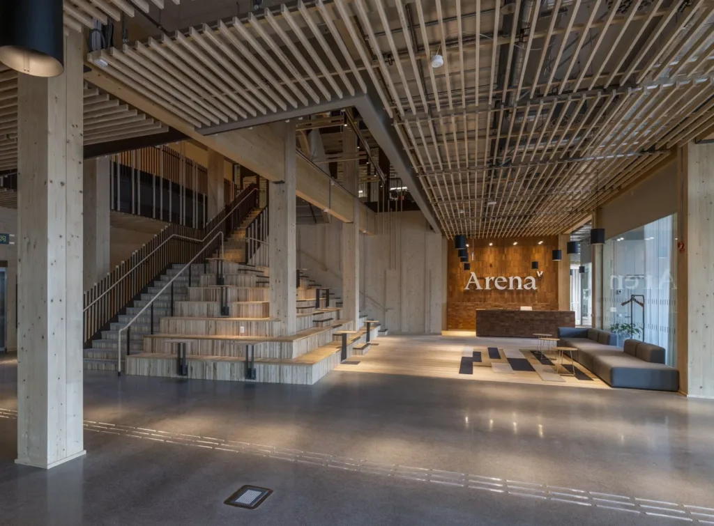 2. Ett stilrent interiört rum med trappor, träpaneler i taket och en reception med texten "Arena".
