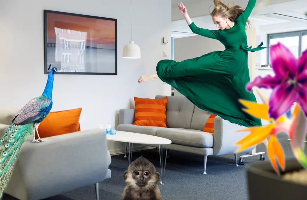 4. En kvinna i grön klänning hoppar bredvid en liten apa i ett vardagsrum med orange kuddar.