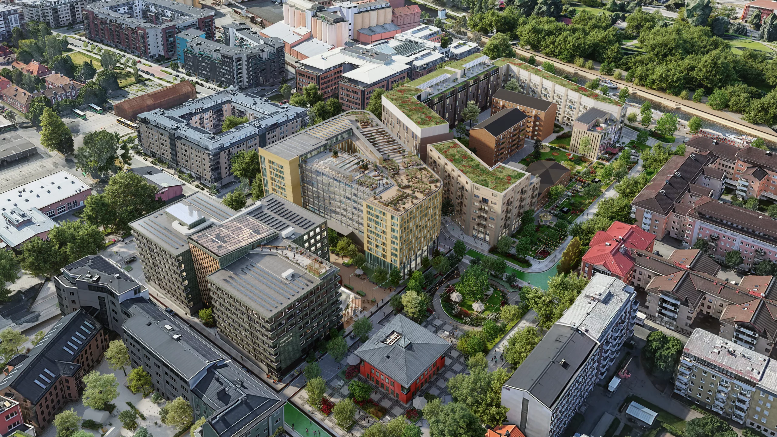 2. En vy från ovan av ett bostadsområde med gröna tak, trädgårdar och byggnader i olika färger.