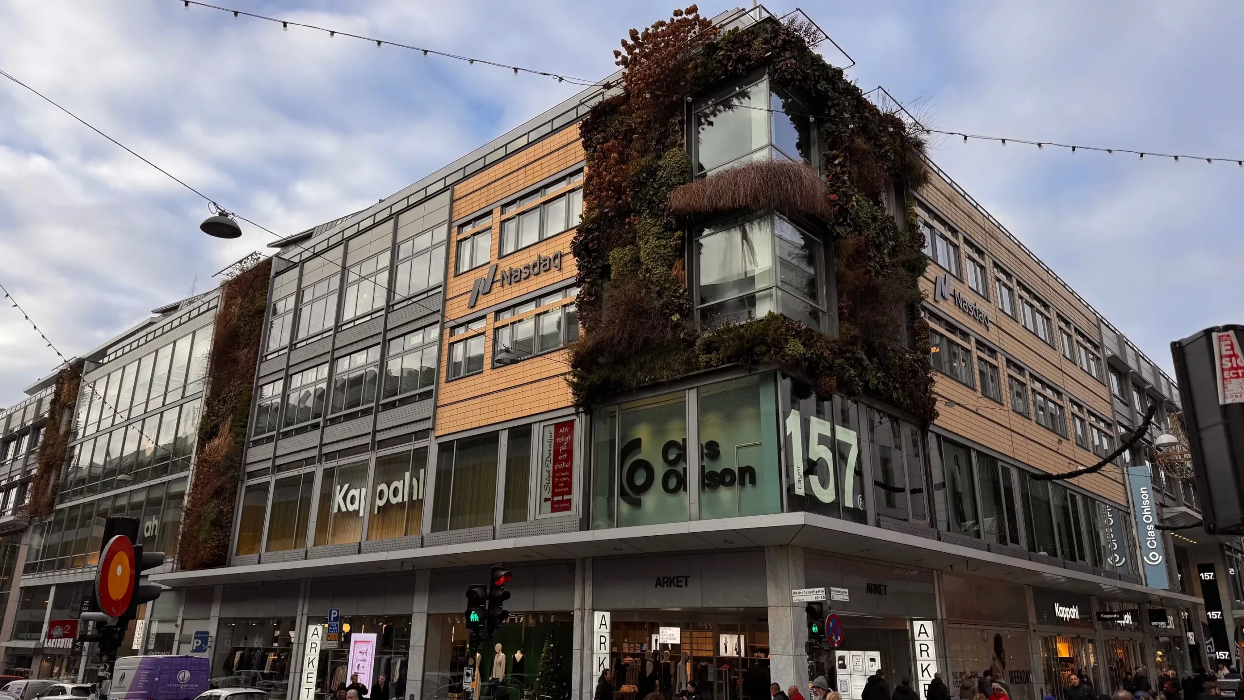 En byggnad med fasad täckt av växtlighet och skyltar med texten "157".