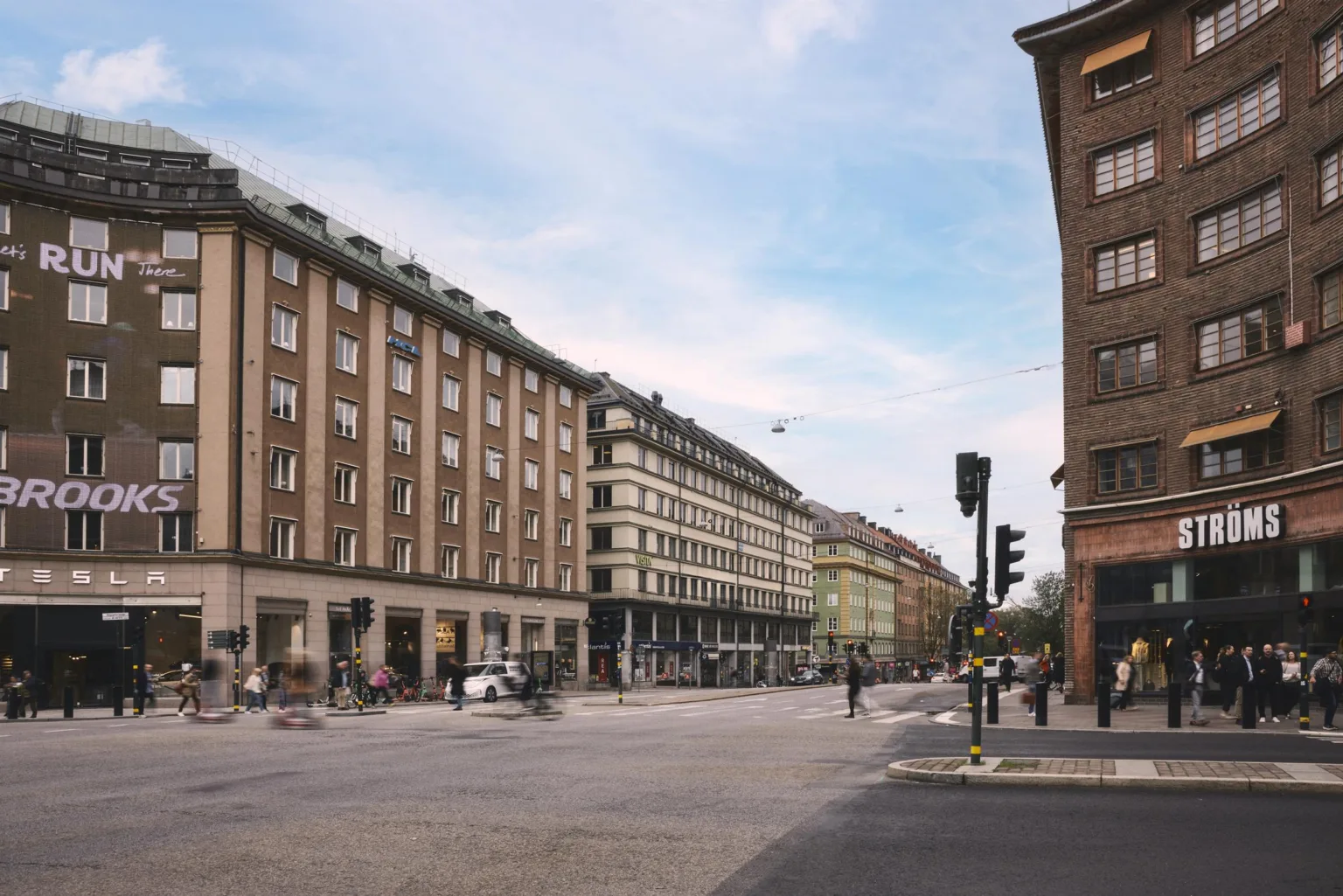 En gata kantad av flerfamiljshus med klassisk arkitektur, och trafikljus vid en korsning.