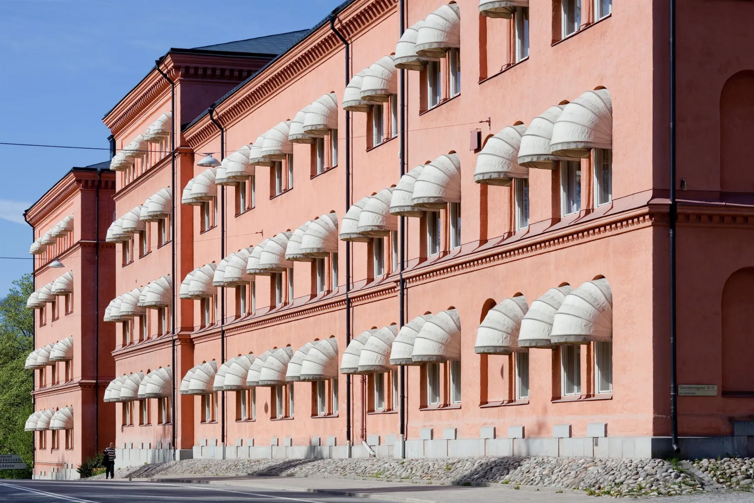 En rad av rosa byggnader med välvda fönster och karakteristiska vita baldakiner.