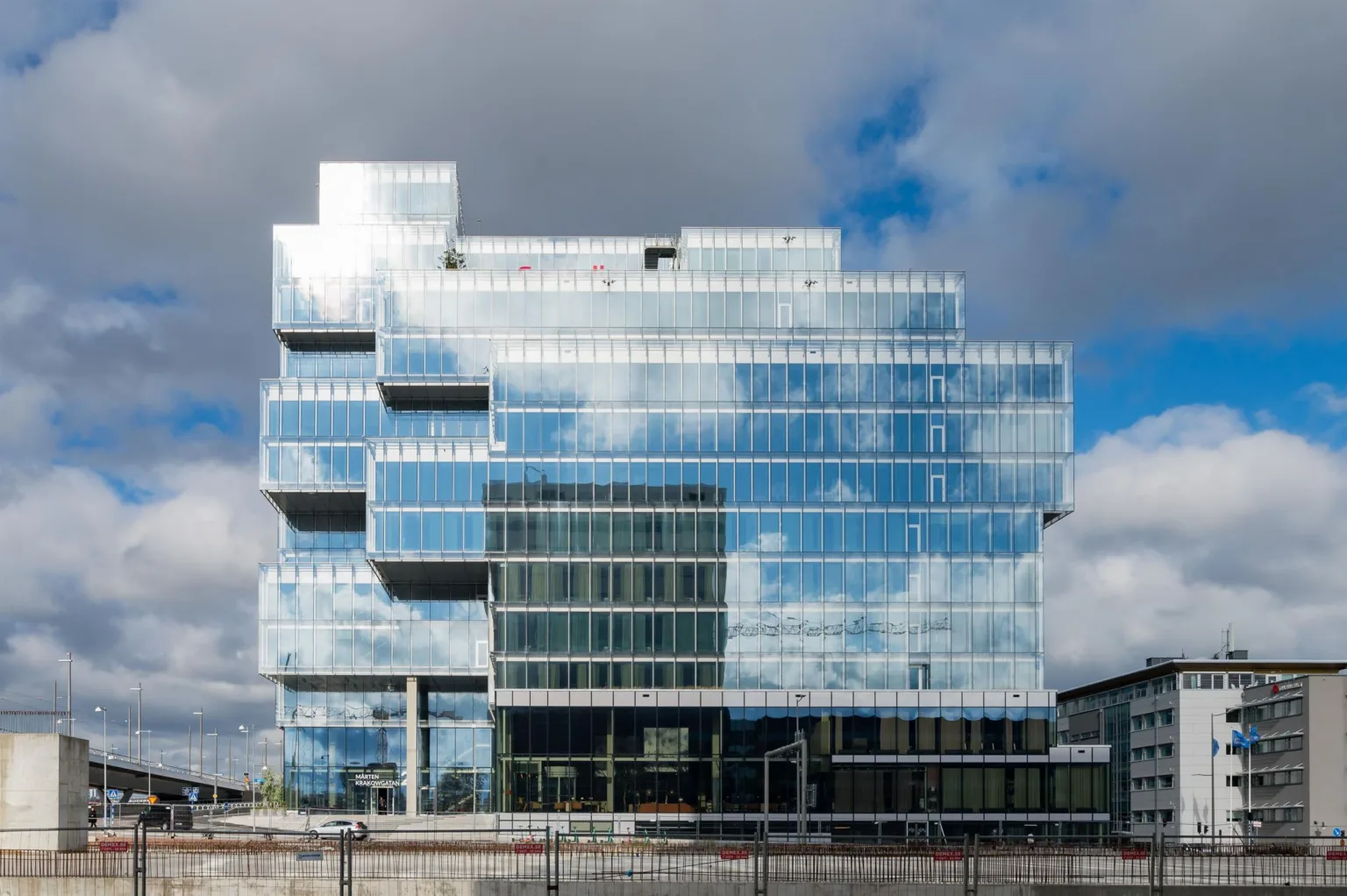 1. En modern byggnad med fasad av glas som reflekterar himlen och moln.