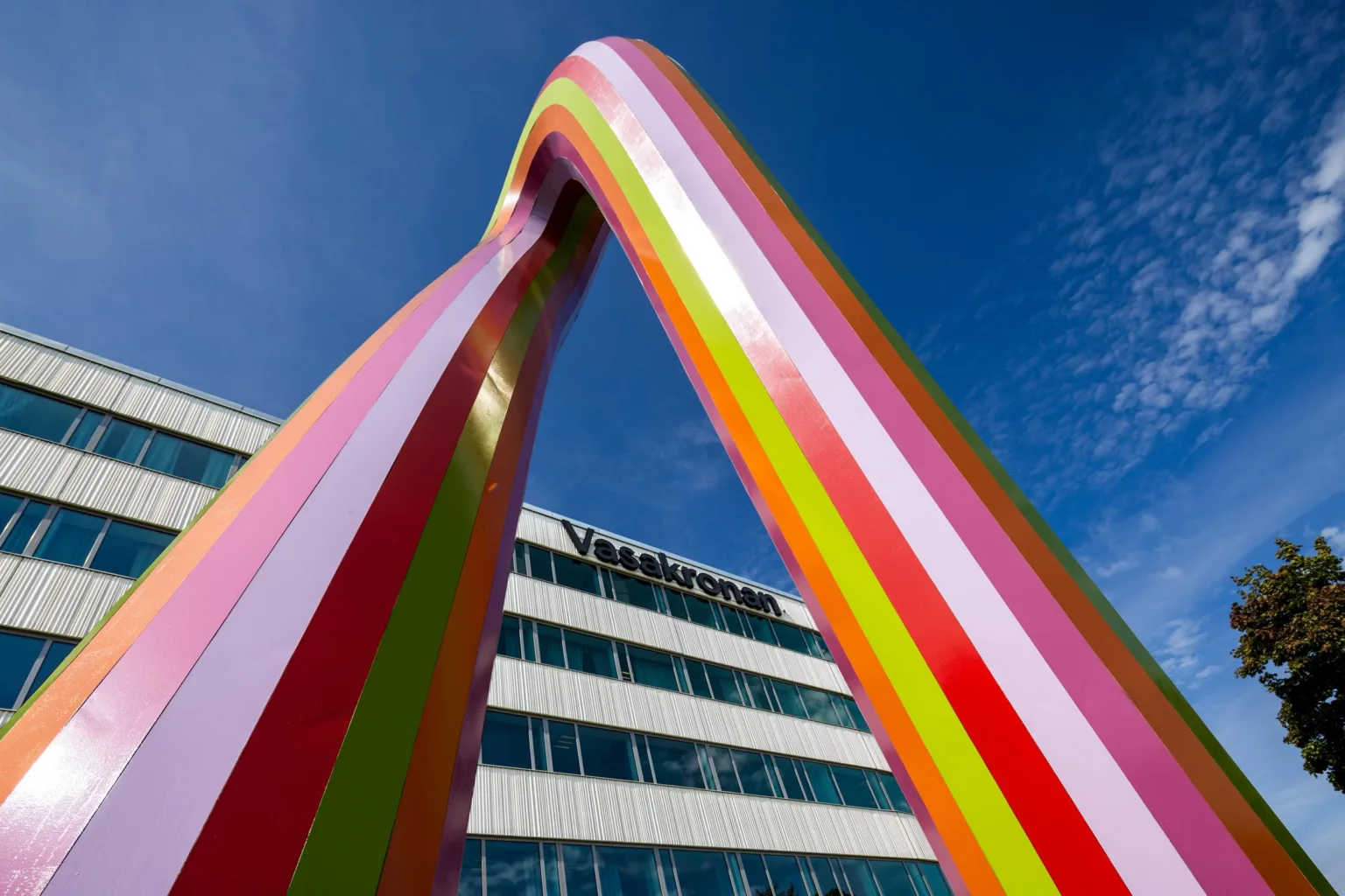 4. En färgglad bågformad skulptur framför en byggnad med texten "Vasakronan".