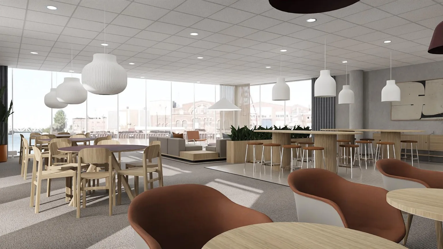 2. En ljus och modern lunch- eller mötesplats med runda bord, stolar och hängande lampor.