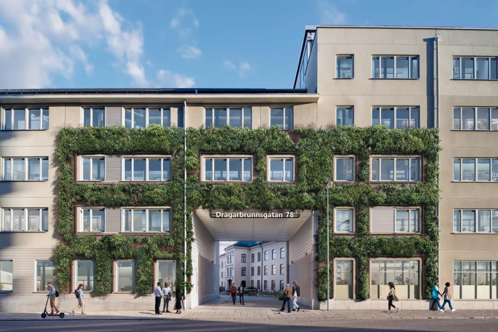 En byggnad täckt med grönska, med en passage som leder till en innergård.