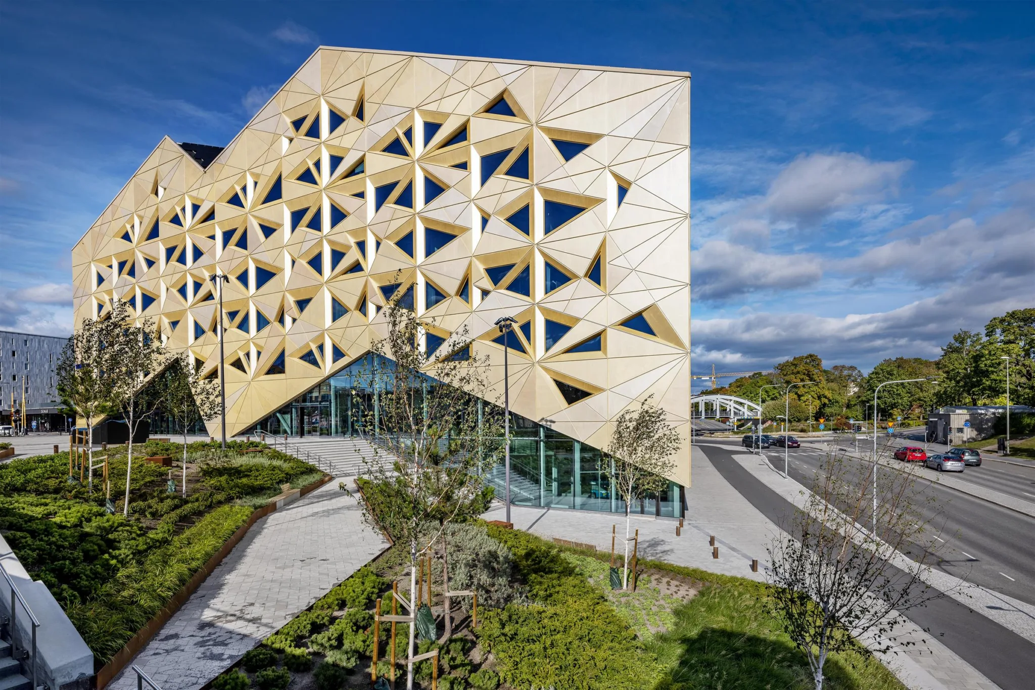 3. En unik byggnad med geometriska mönster och gröna omgivningar under en klar blå himmel.