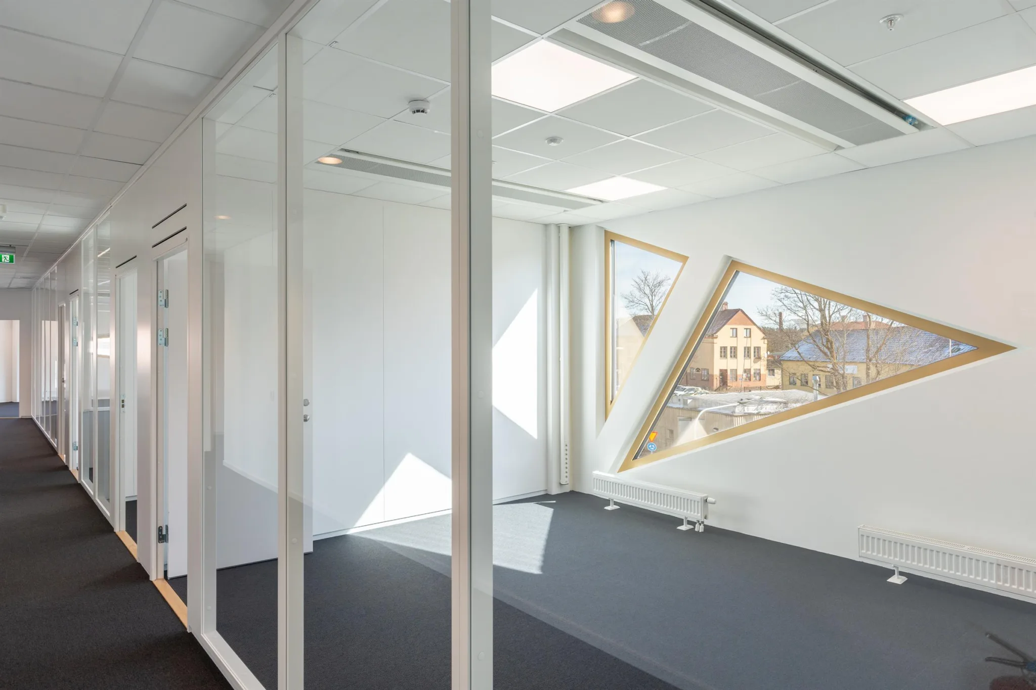 3. Ett ljust kontorsrum med geometriska fönster som visar utsikten utanför.