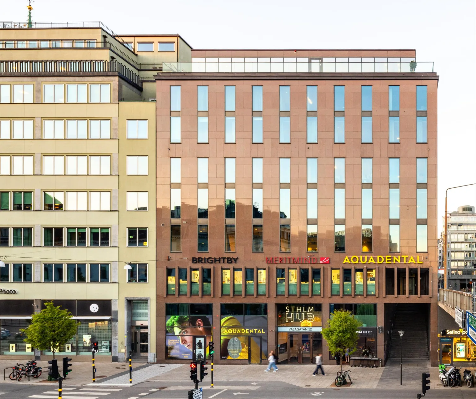 En fasad av en kontorsbyggnad i flera våningar med stora fönster och entréer på bottenvåningen.