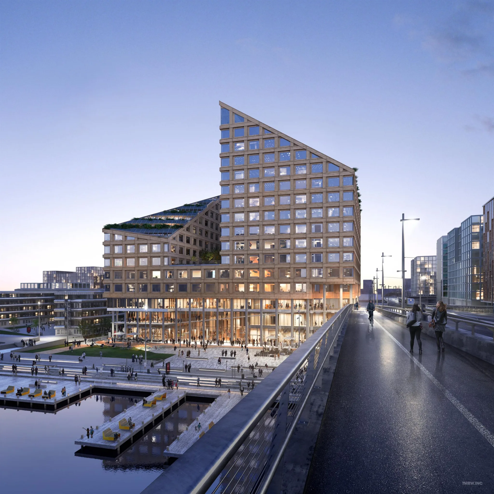 Byggnad med modern arkitektur vid vattnet, upplyst under skymning.