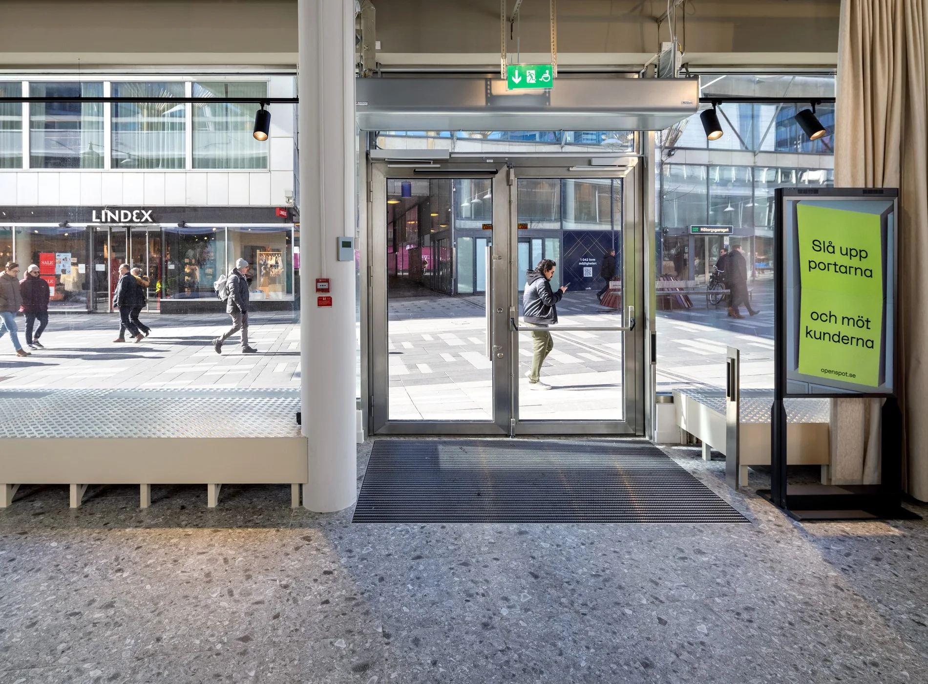 4. En glasentré med människor utanför och skyltar på insidan.