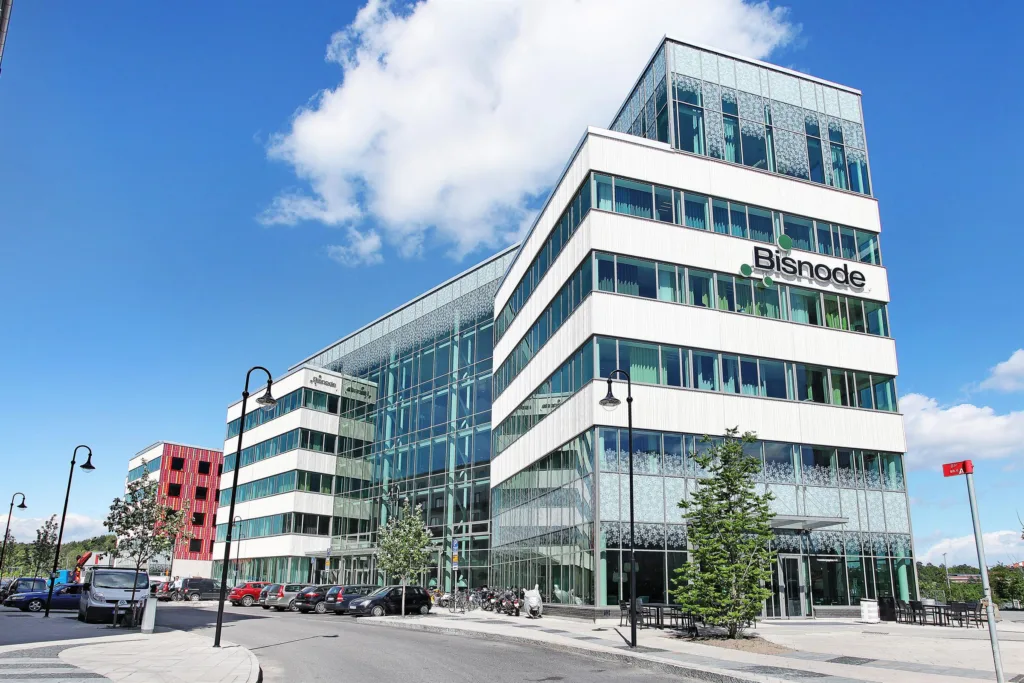 En modern byggnad med glasfasad, med texten "Bisnode" synlig på fasaden.