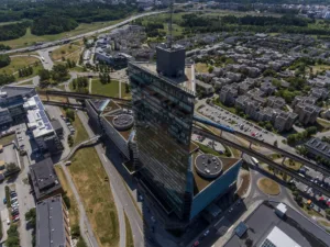 1. En hög byggnad med glasfasad omgiven av stadslandskap och vägar.
