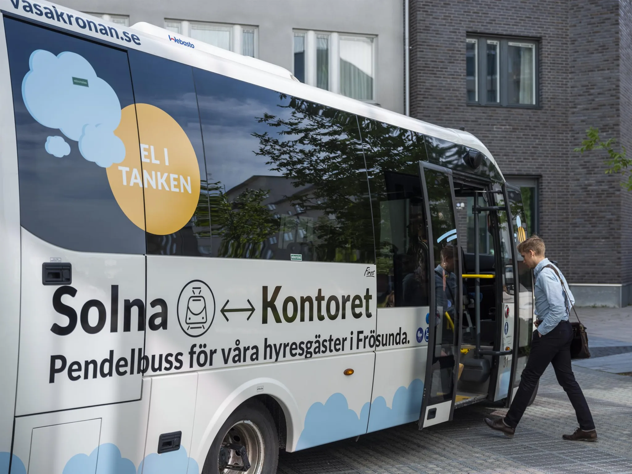 En eldriven pendelbuss med texten "Solna ↔ Kontoret" och personer som stiger ombord.