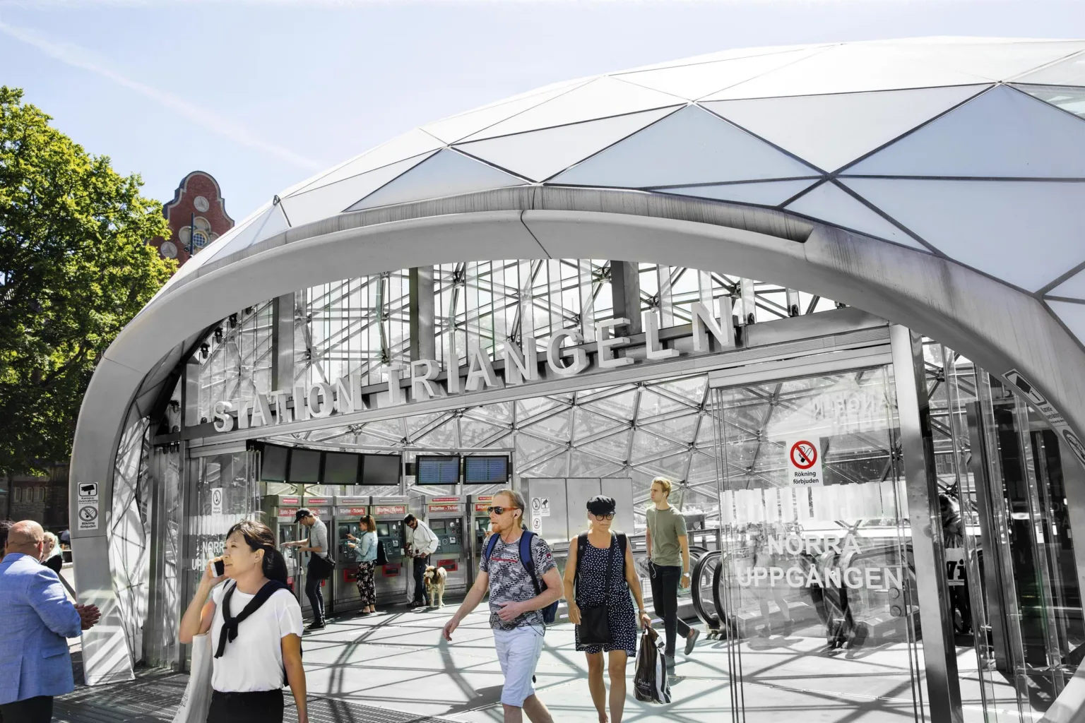 2. Entrén till Malmö Triangeln med glasfasad och fotgängare som rör sig runt området.