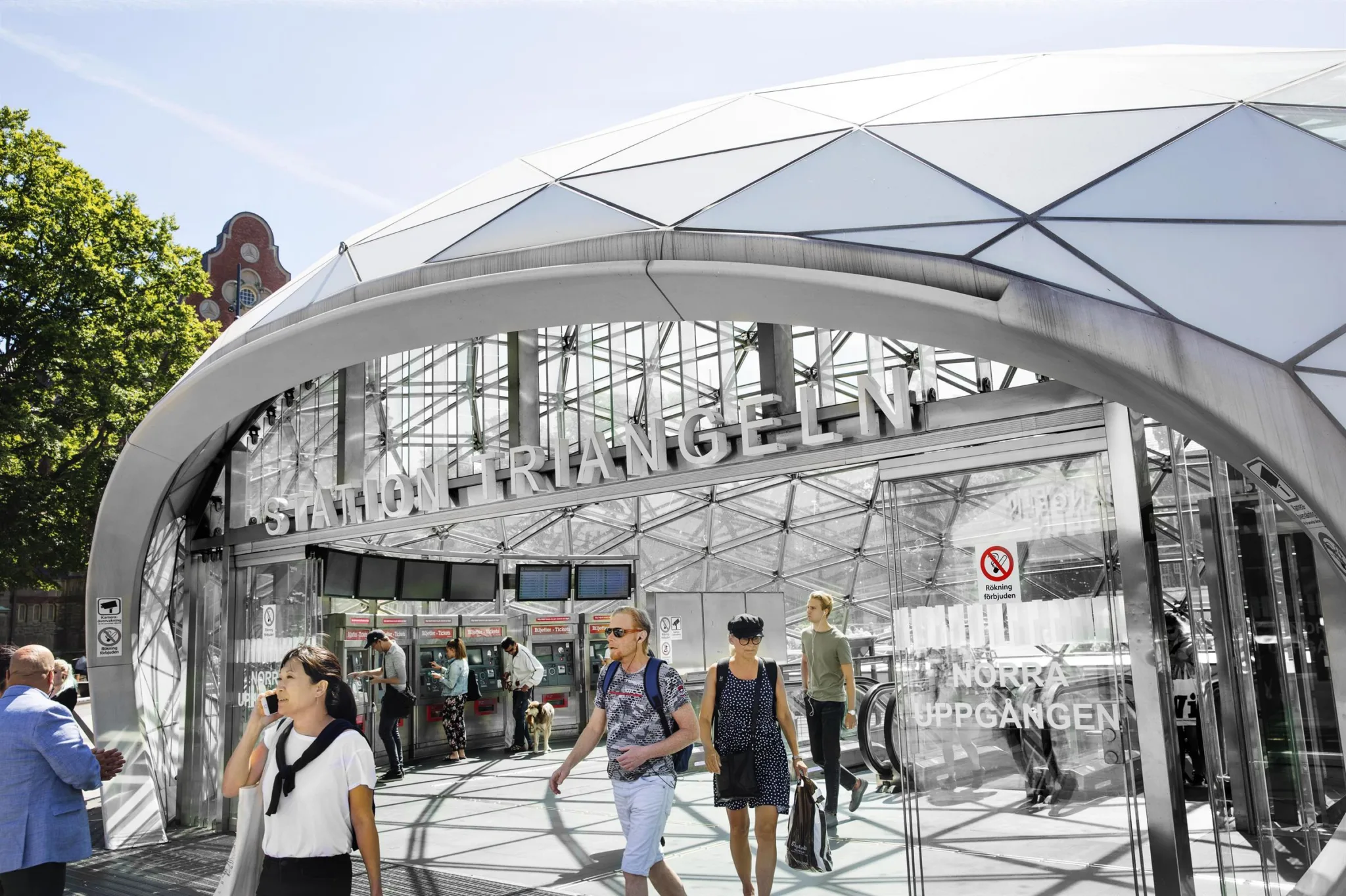 2. Entrén till Malmö Triangeln med glasfasad och fotgängare som rör sig runt området.