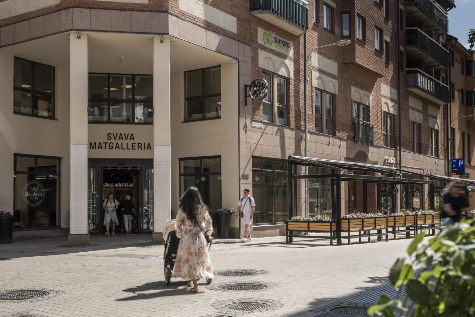 Entré till en matgalleria med människor som går framför byggnaden.