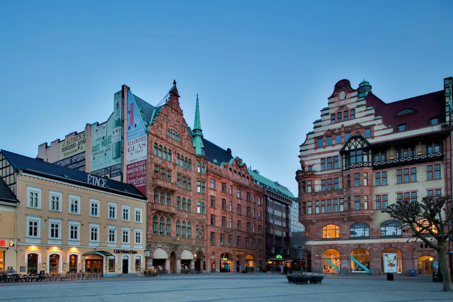 Ett torg med flera färgglada och historiska byggnader, en öppen plats med blå himmel.