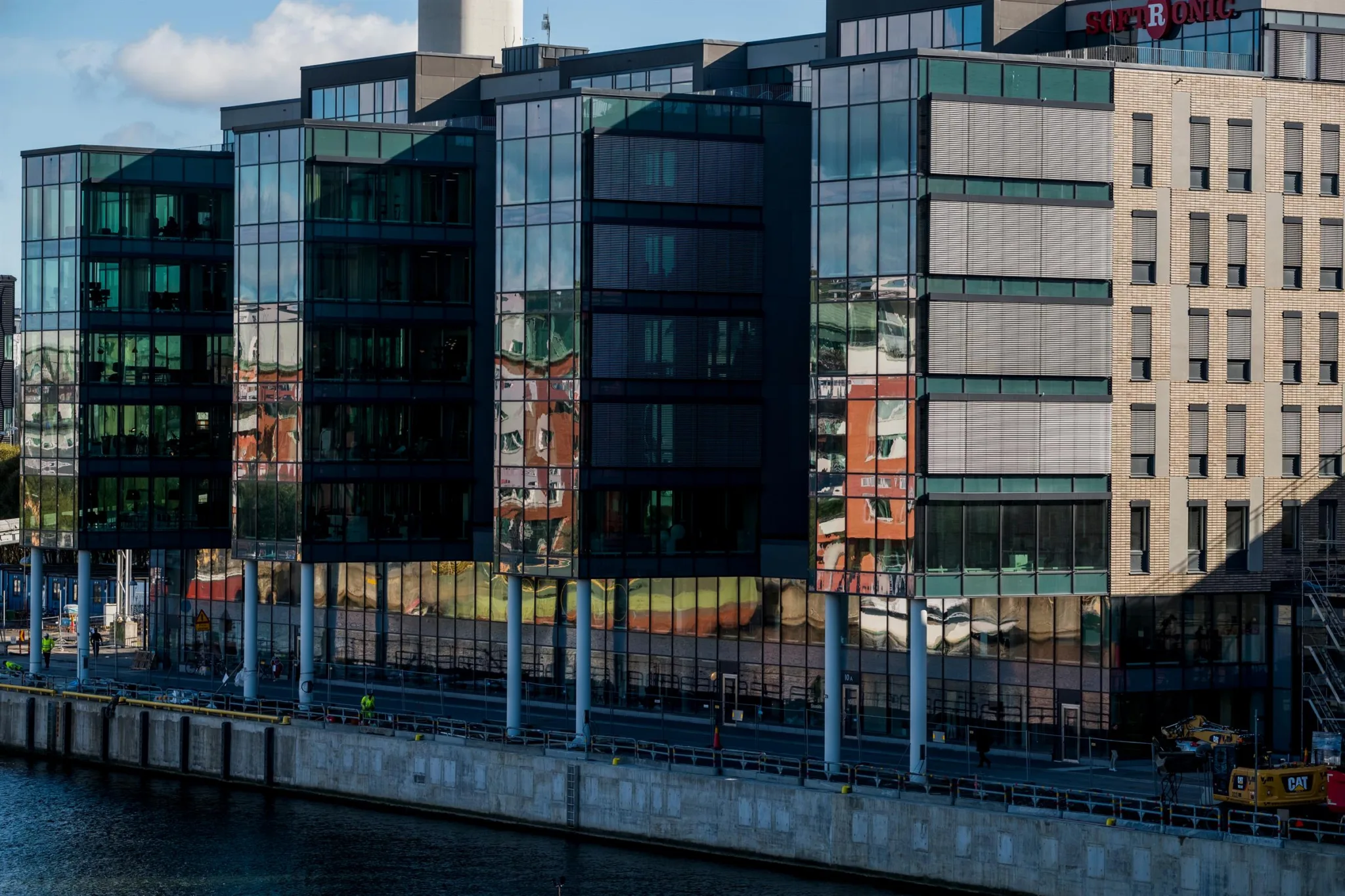 4. En byggnad med glasfasader vid vattnet, reflekterande omgivningen.