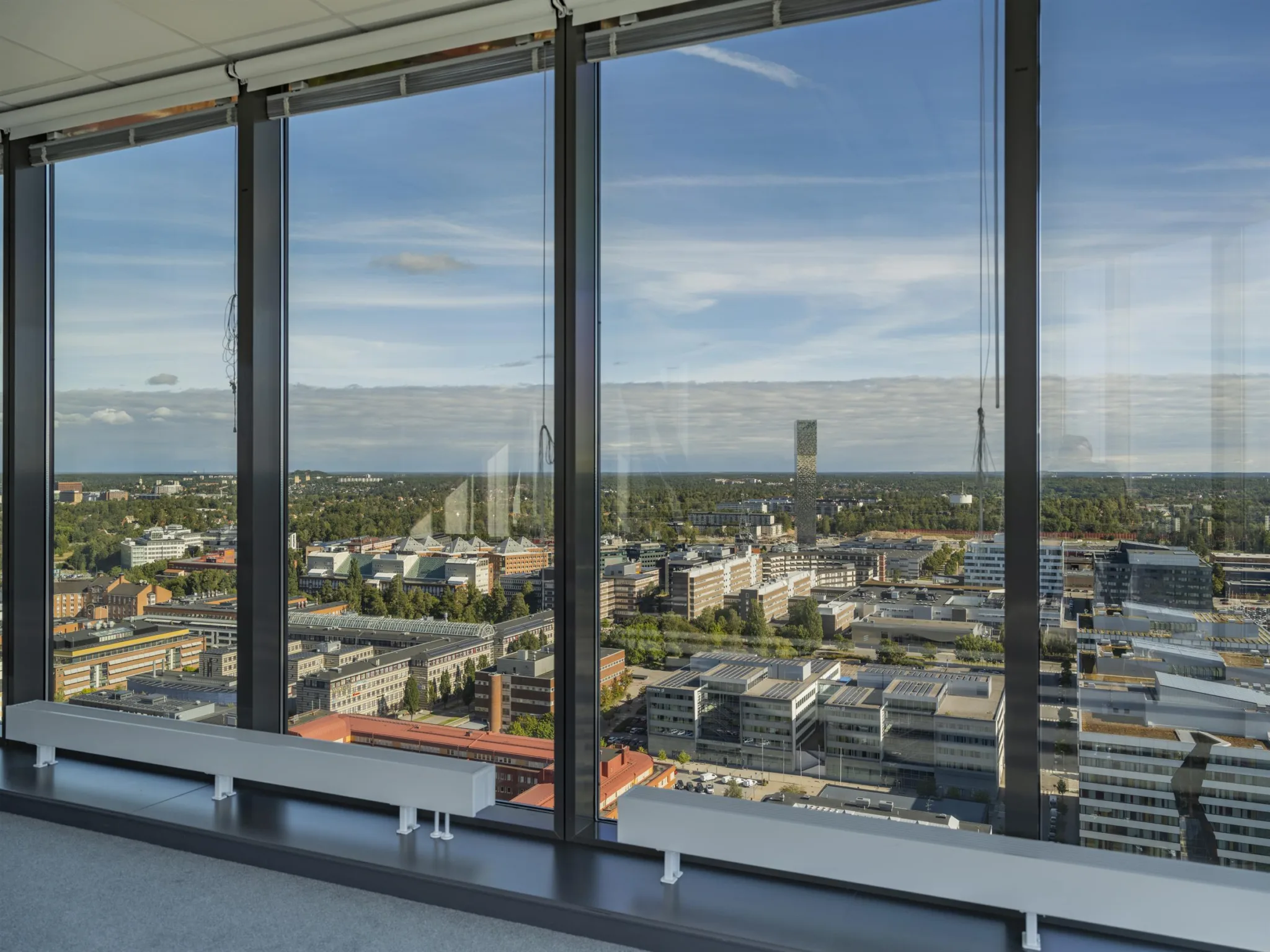 1. Utsikt över en stad genom stora glasfönster från en hög byggnad.