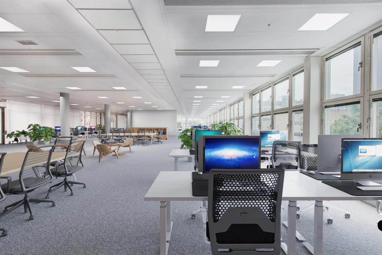 En modern kontorsmiljö med skrivbord, datorer och stora fönster.