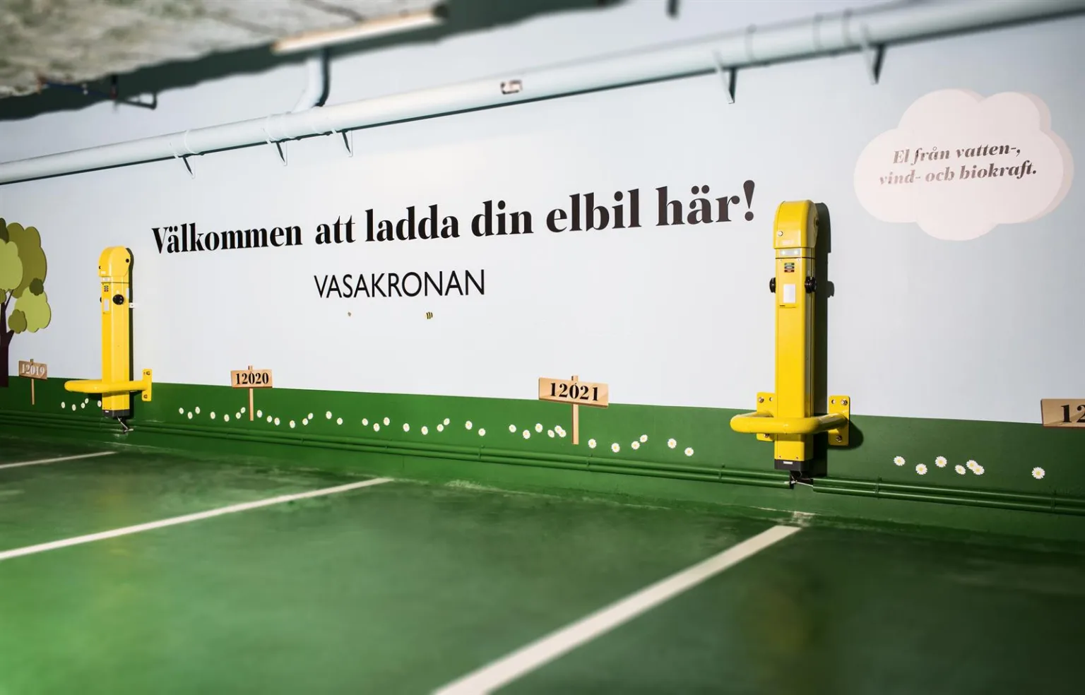 En laddstation för elbilar med texten "Välkommen att ladda din elbil här! Vasakronan."