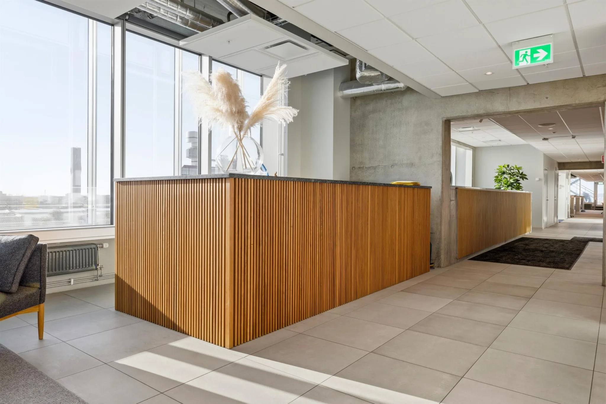 En reception med träpaneler och dekorativa torkade växter ovanpå.