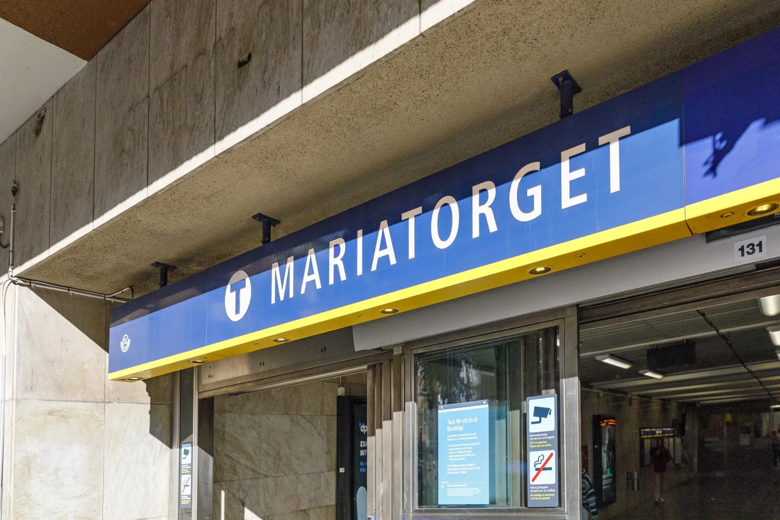 En skylt med texten "Mariatorget" ovanför ingången till en tunnelbanestation.