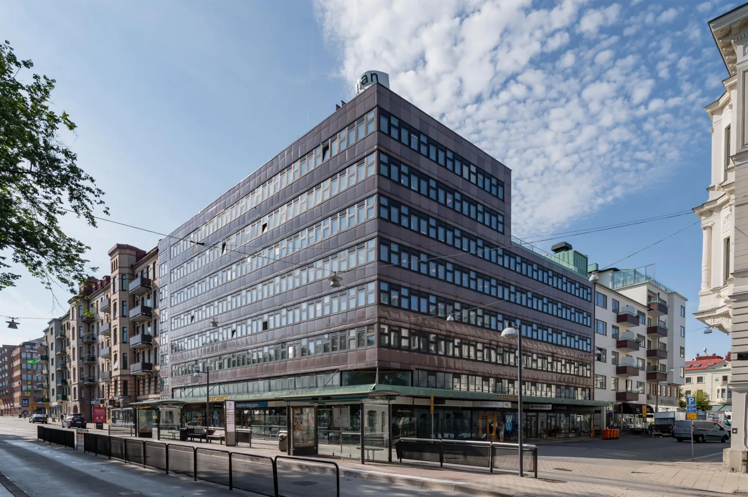 1. En modern kontorsbyggnad med flera våningar, stora fönster och en blå himmel i bakgrunden.