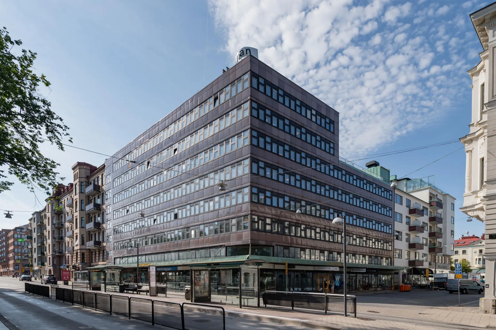 1. En modern kontorsbyggnad med flera våningar, stora fönster och en blå himmel i bakgrunden.