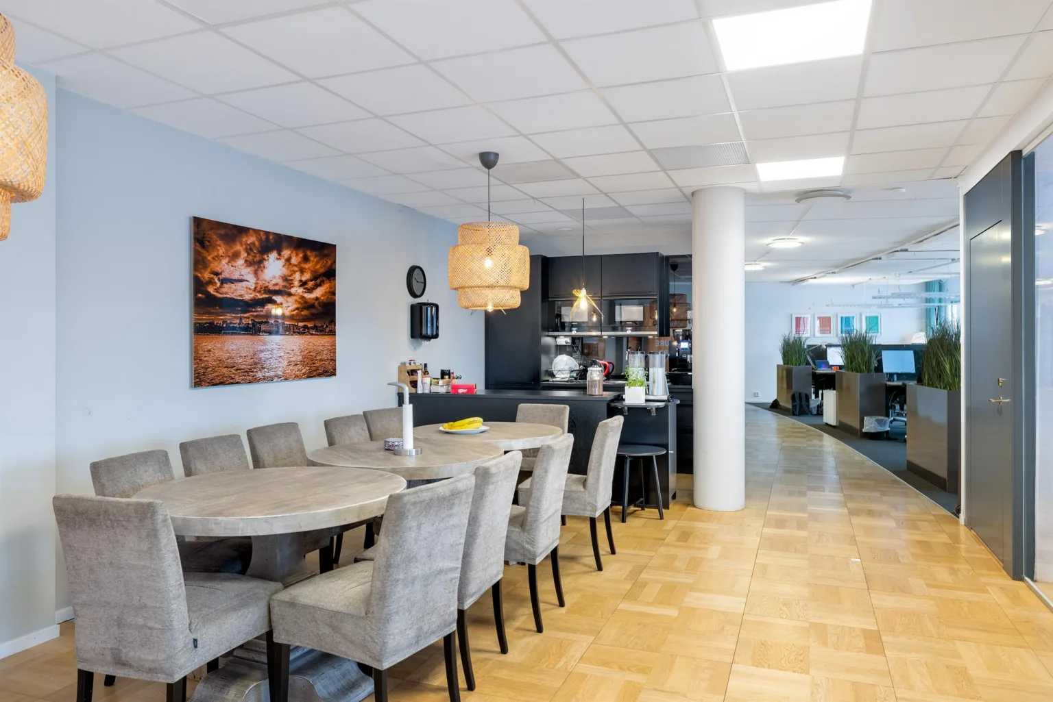 4. Ett kök med ett matbord och stolar, en taklampa och en konsttavla på väggen.