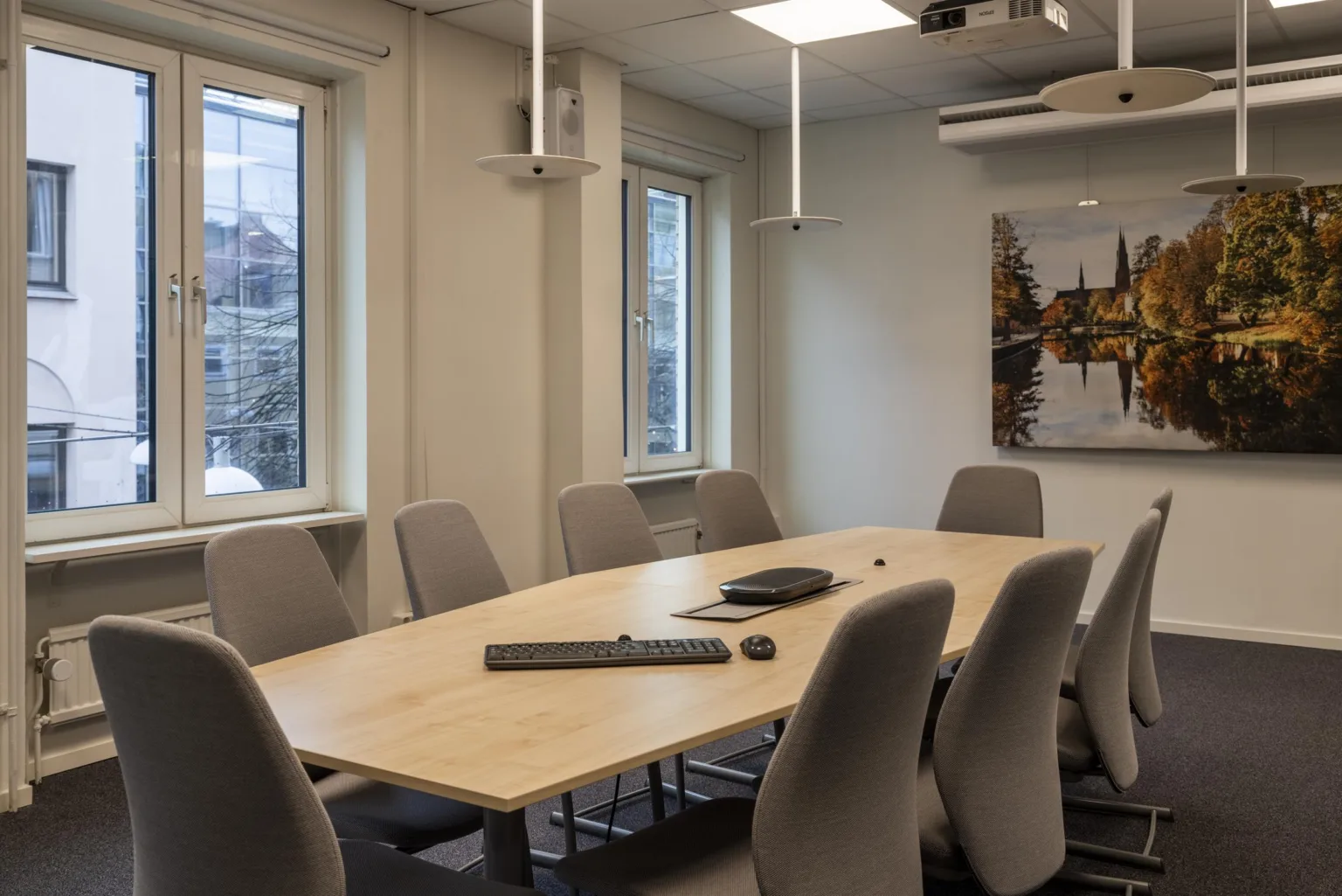 1. Ett konferensrum med ett långt bord, flera stolar och väggdekorationer.