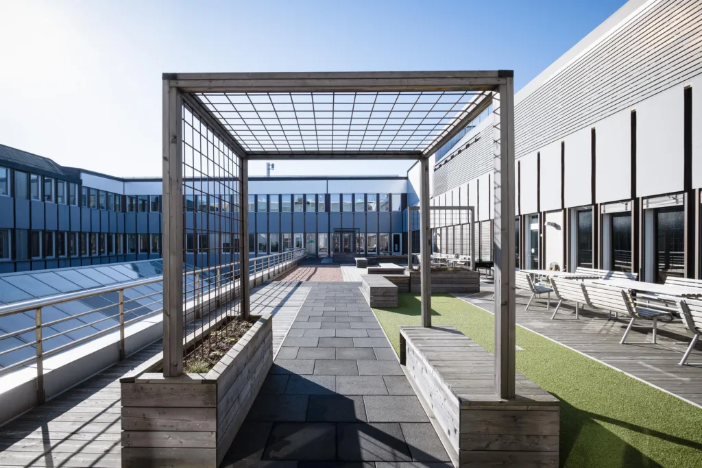 4. En takterrass med pergola, planteringslådor och sittplatser i en modern miljö.