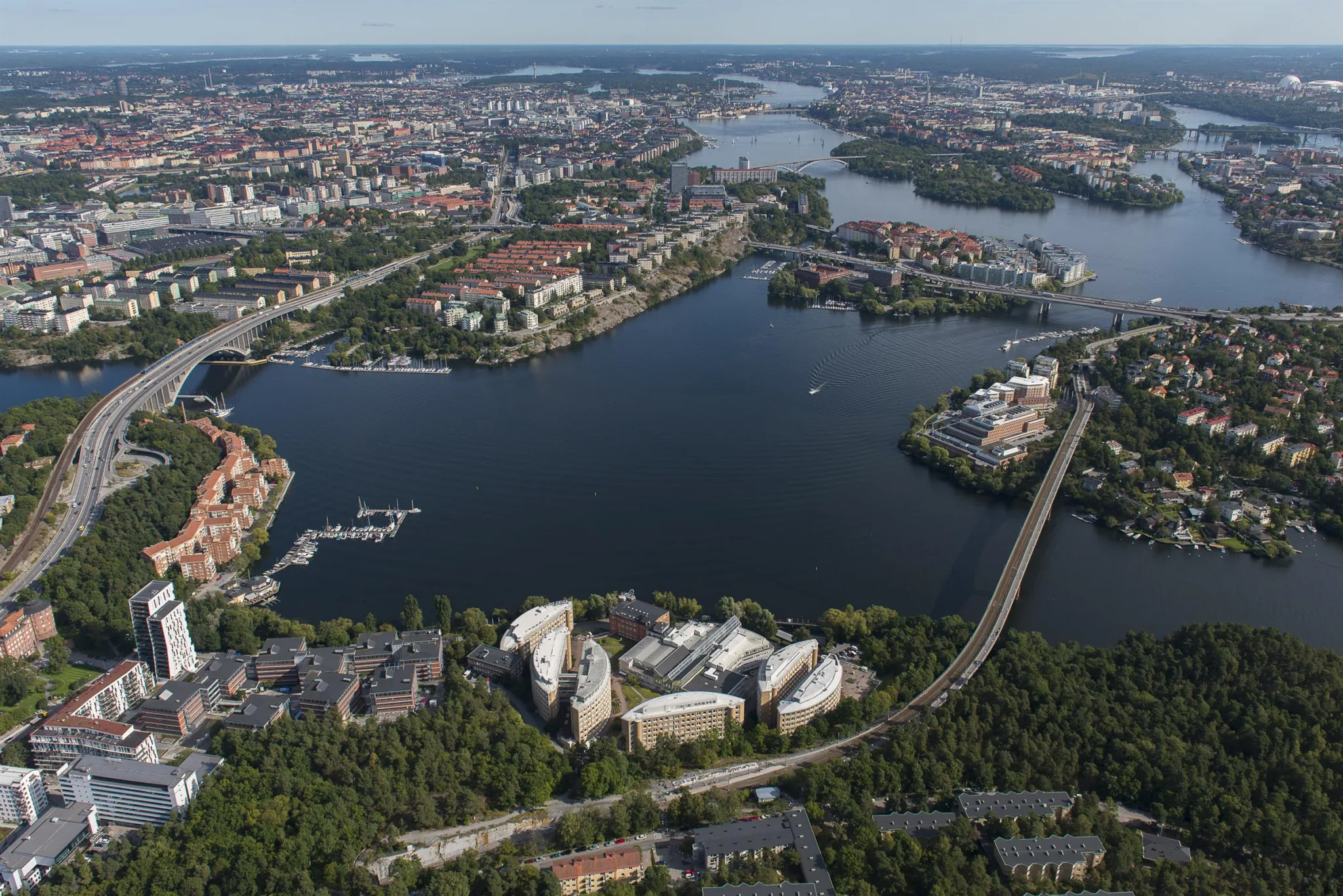 Panoramavy över stad med vatten, broar, byggnader och grönområden.