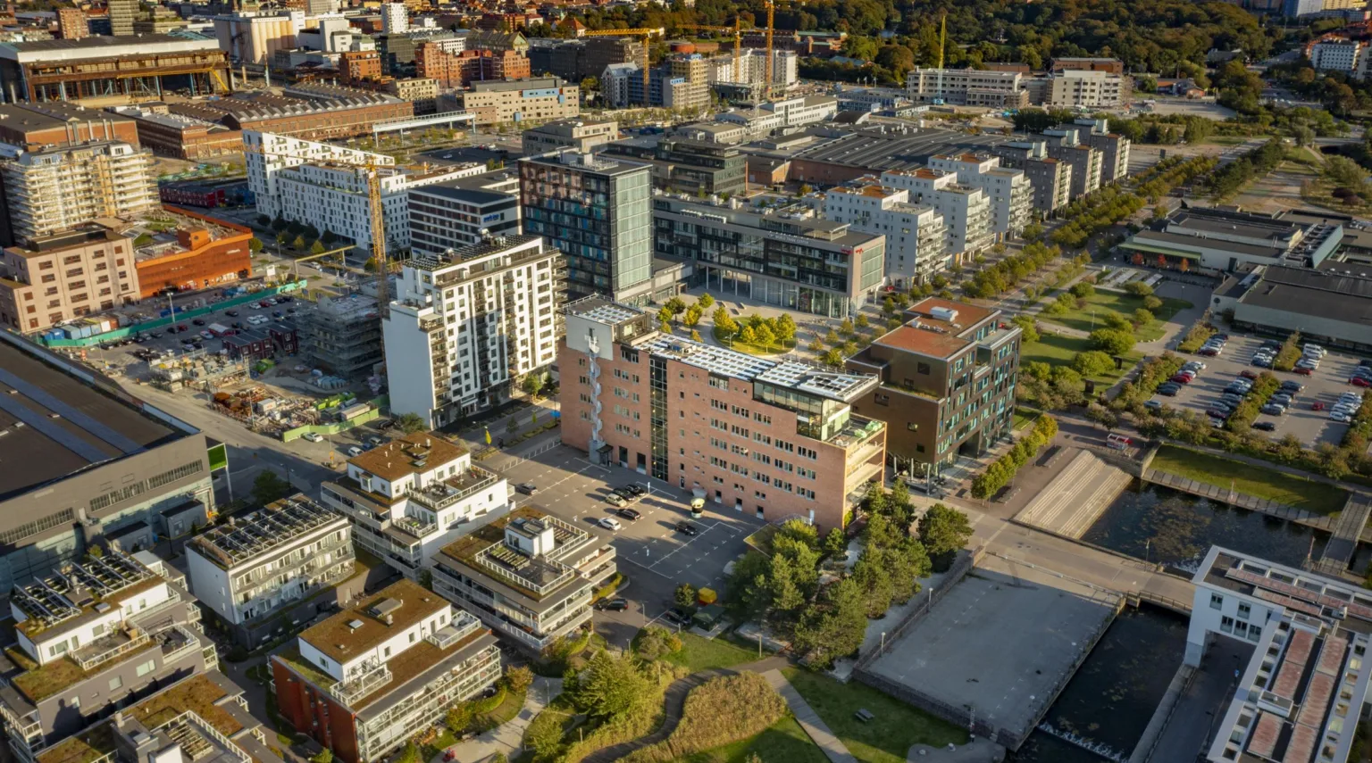 En stadsvy från ovan med flera moderna byggnader och grönområden.