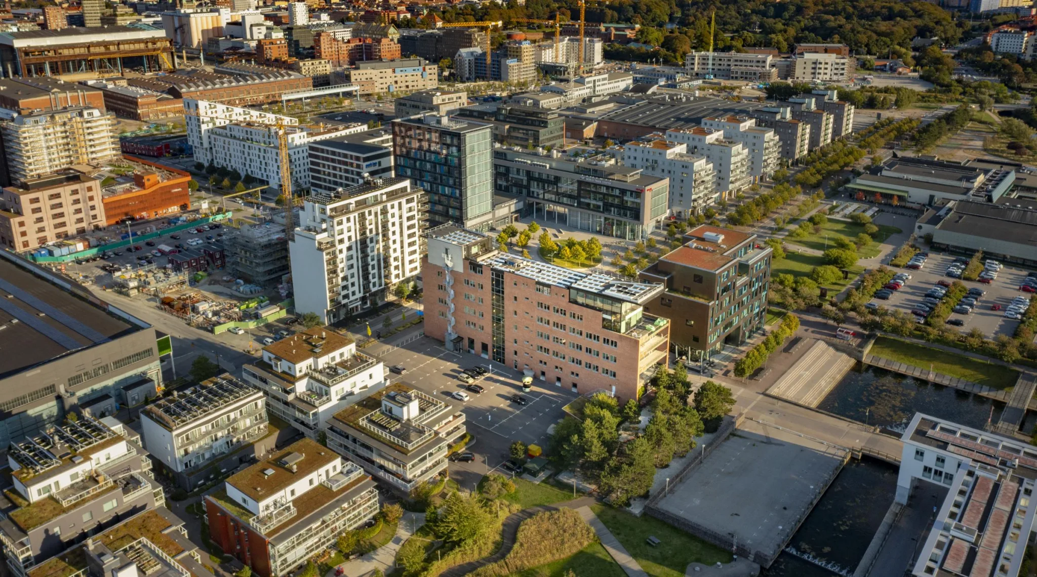 En stadsvy från ovan med flera moderna byggnader och grönområden.